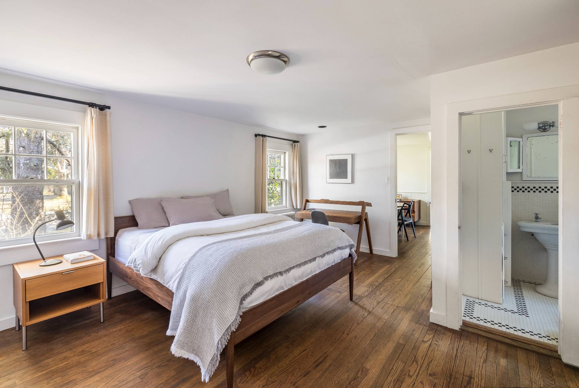 11 Cove Avenue East Sag Harbor, NY 11963 - Photo 9 of 19 a spacious bedroom with a bed a table and three large mirror with wooden floor