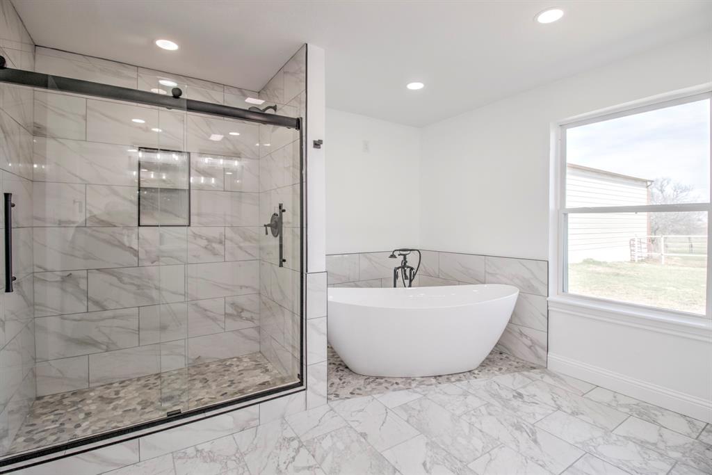 3884 Lois Road East Sanger, TX 76266 - Photo 33 of 40 a bathroom with a bathtub a shower and a window