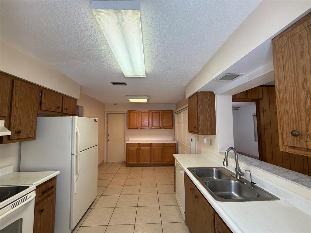 7508 Northwest 67th Avenue Tamarac, FL 33321 - Photo 15 of 17 a kitchen that has a sink a refrigerator and a stove top oven