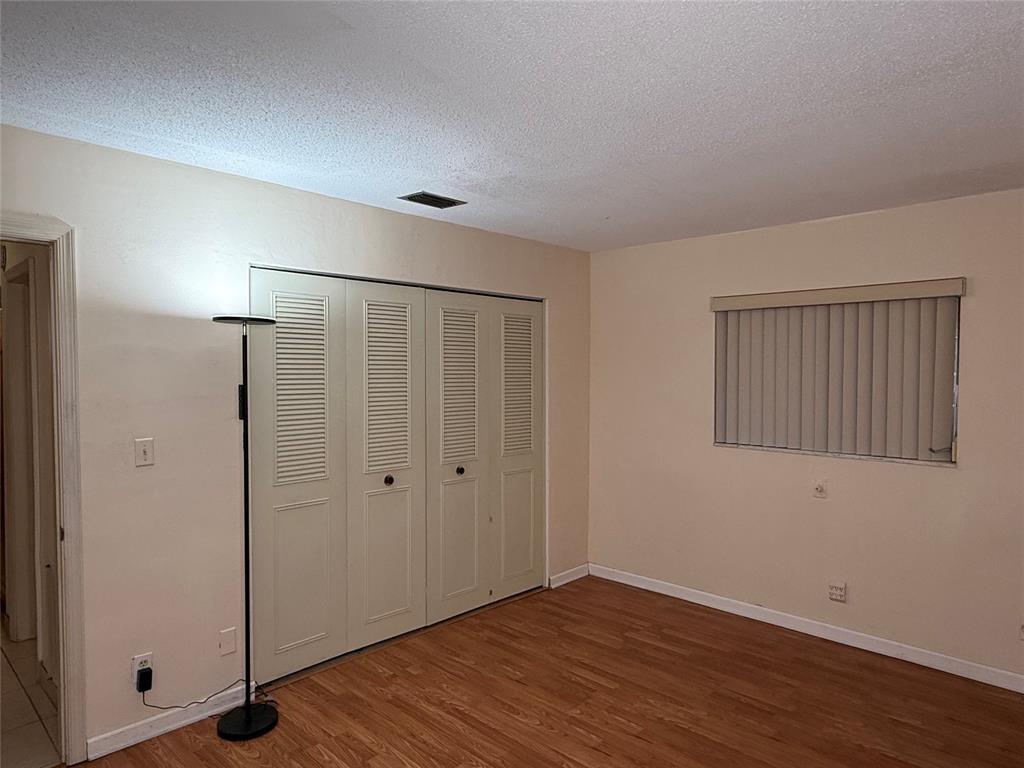 7508 Northwest 67th Avenue Tamarac, FL 33321 - Photo 9 of 17 an empty room with wooden floor and windows