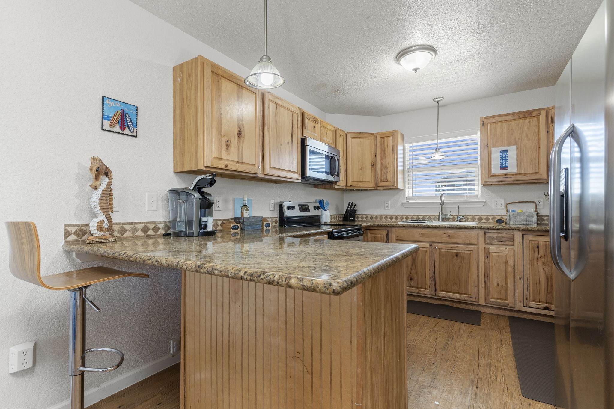 111 Howard Avenue Surfside Beach, TX 77541 - Photo 22 of 33 a kitchen with stainless steel appliances granite countertop a sink a stove and a refrigerator
