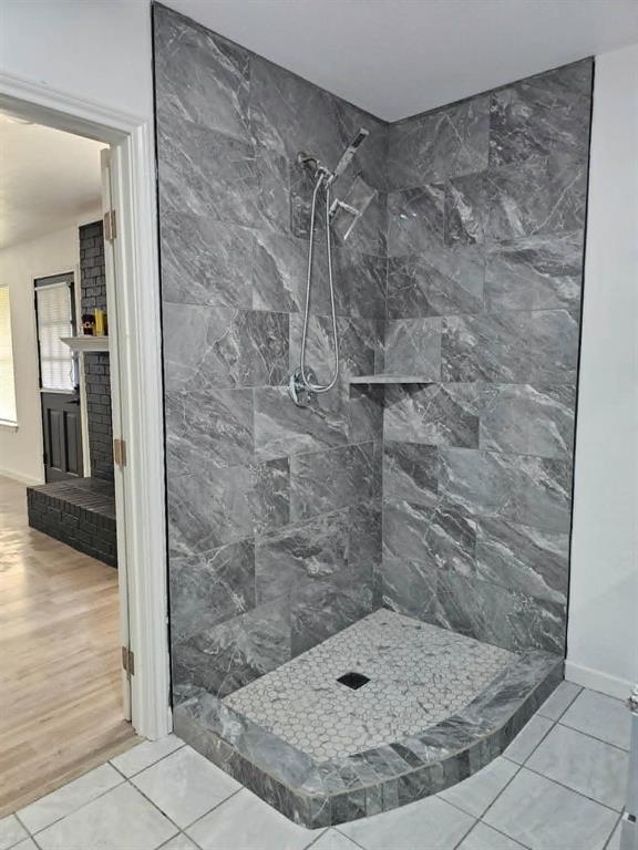 2908 Legend Road Arlington, TX 76014 - Photo 22 of 29 Corner shower featuring large format gray marble-look tile walls, a built-in shower niche, and a hexagonal mosaic tile floor