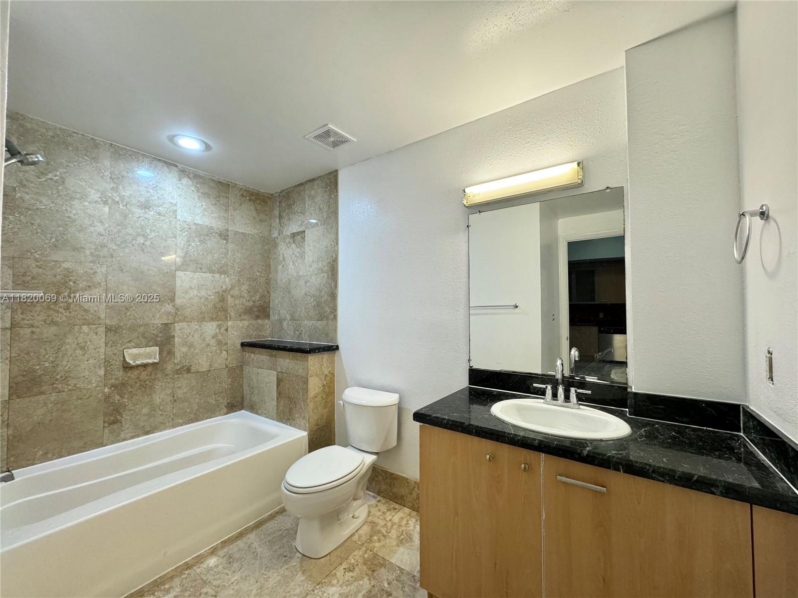 1350 Northwest 8th Court, Unit B35 Miami, FL 33136 - Photo 11 of 22 a bathroom with a granite countertop sink toilet and shower