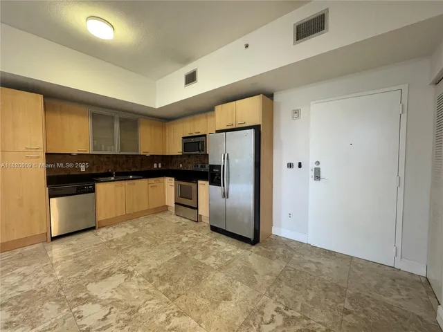 a kitchen with refrigerator and cabinets