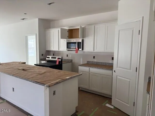 a kitchen with white cabinets and appliances