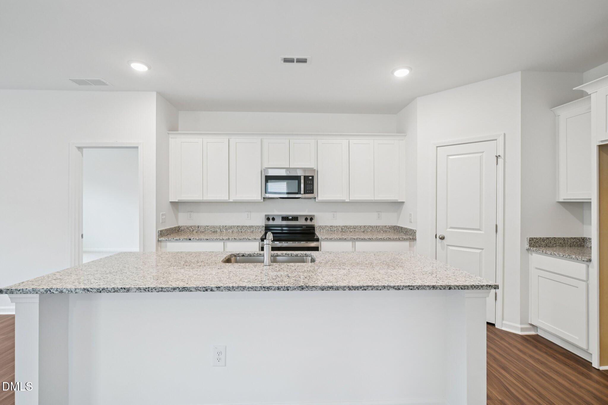 11210 Salers Loop Middlesex, NC 27557 - Photo 18 of 53 a kitchen with stainless steel appliances granite countertop a stove a sink and a refrigerator
