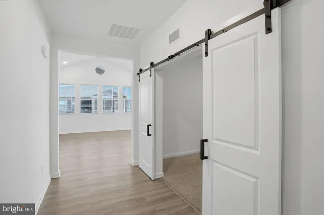 a view of a big room with wooden floor and windows