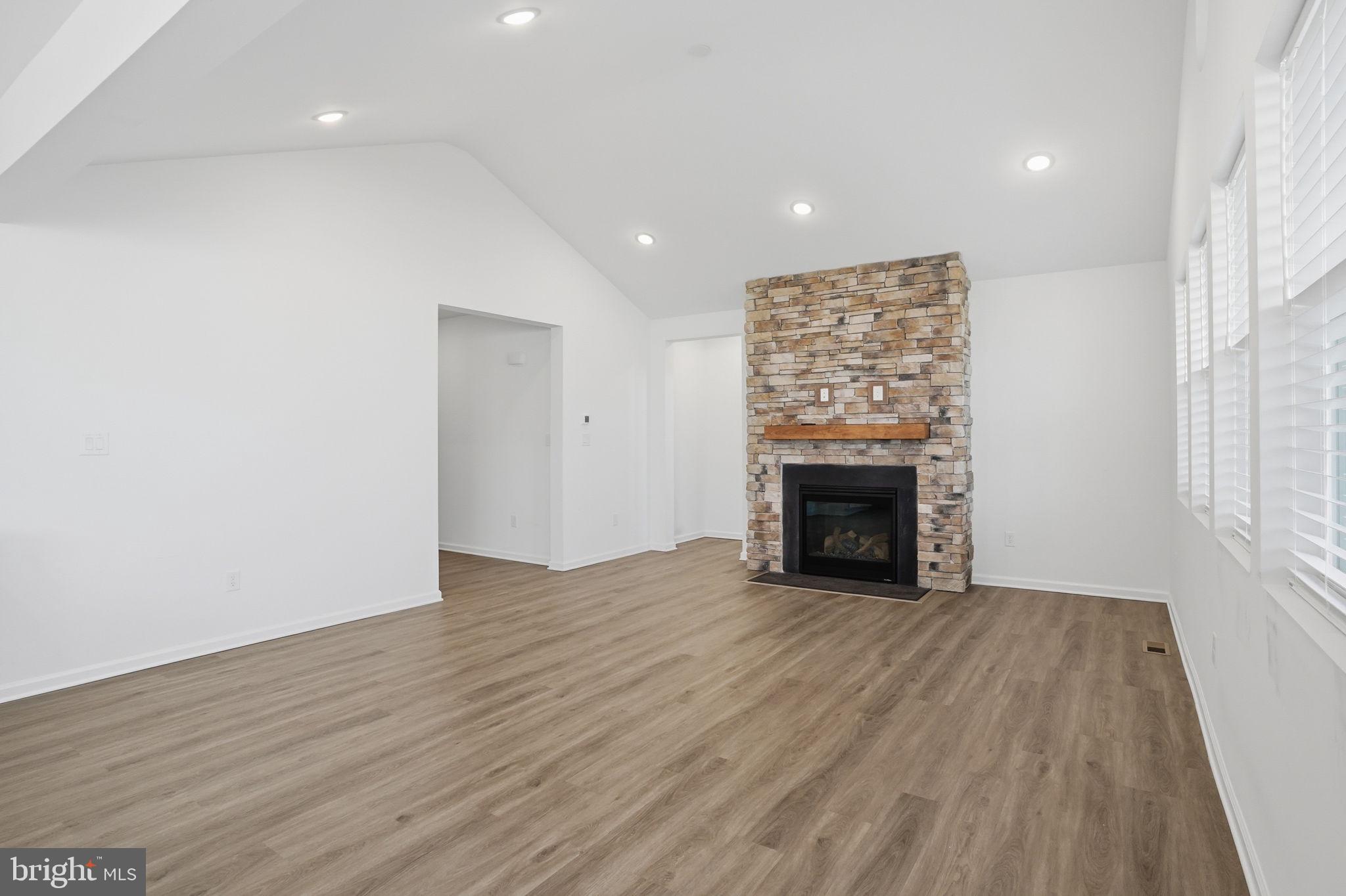 23402 Buttonbush Way Millville, DE 19967 - Photo 27 of 52 a view of an empty room with wooden floor fireplace and a window