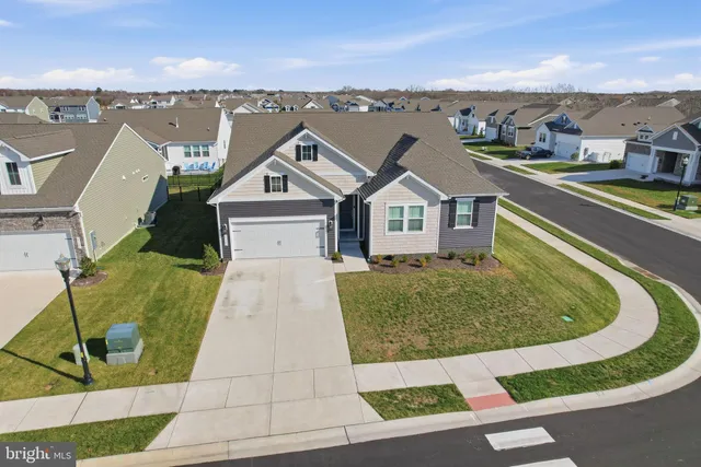 an aerial view of a house with a garden and lake view