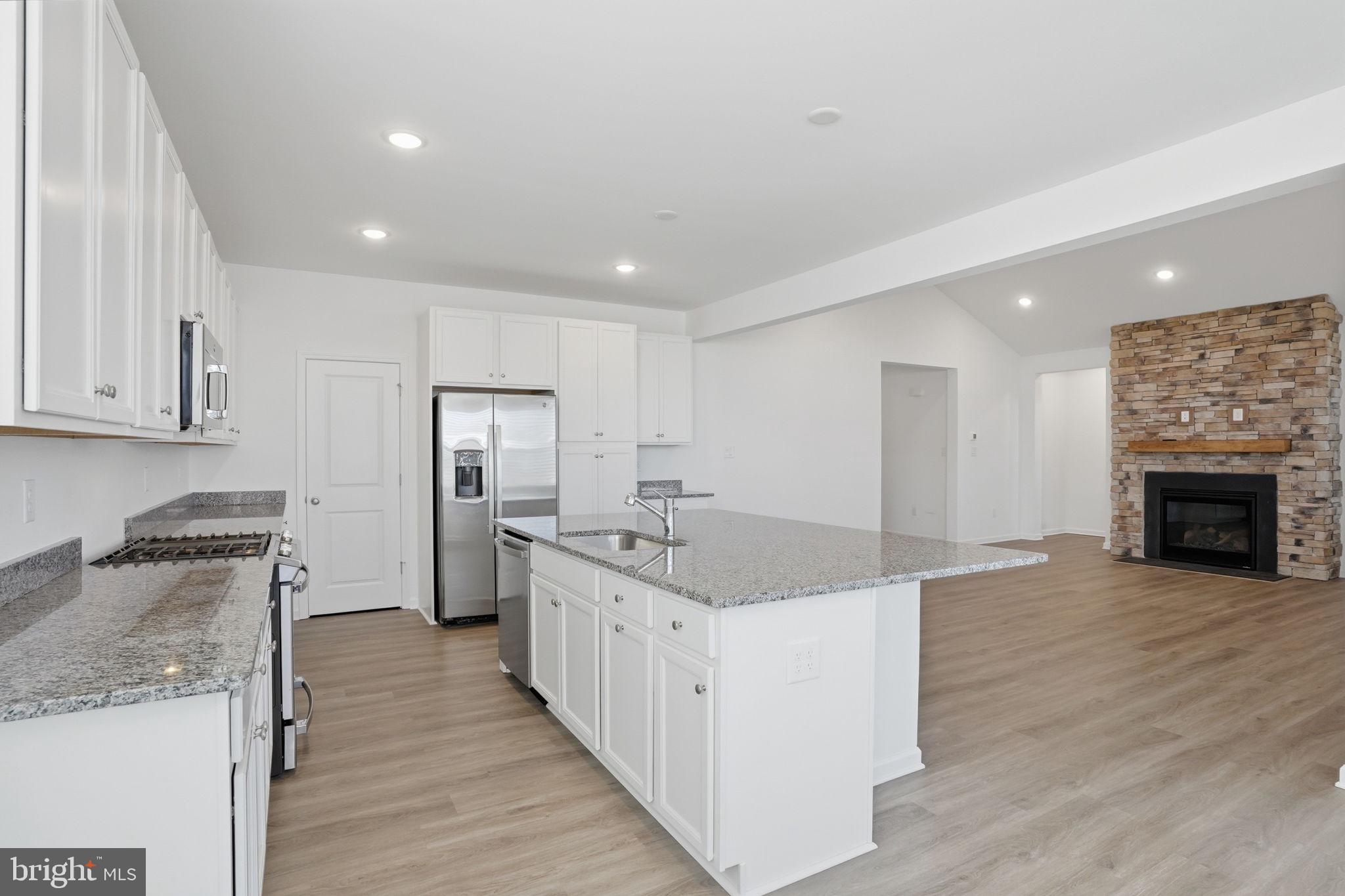 23402 Buttonbush Way Millville, DE 19967 - Photo 34 of 52 a kitchen with stainless steel appliances granite countertop a sink stove and refrigerator