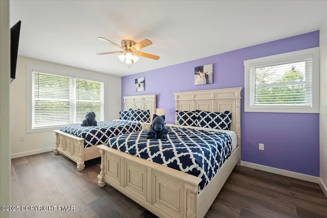 a bedroom with two beds and windows