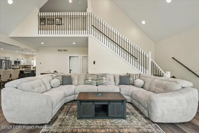 a view of a hallway with wooden floor and staircase