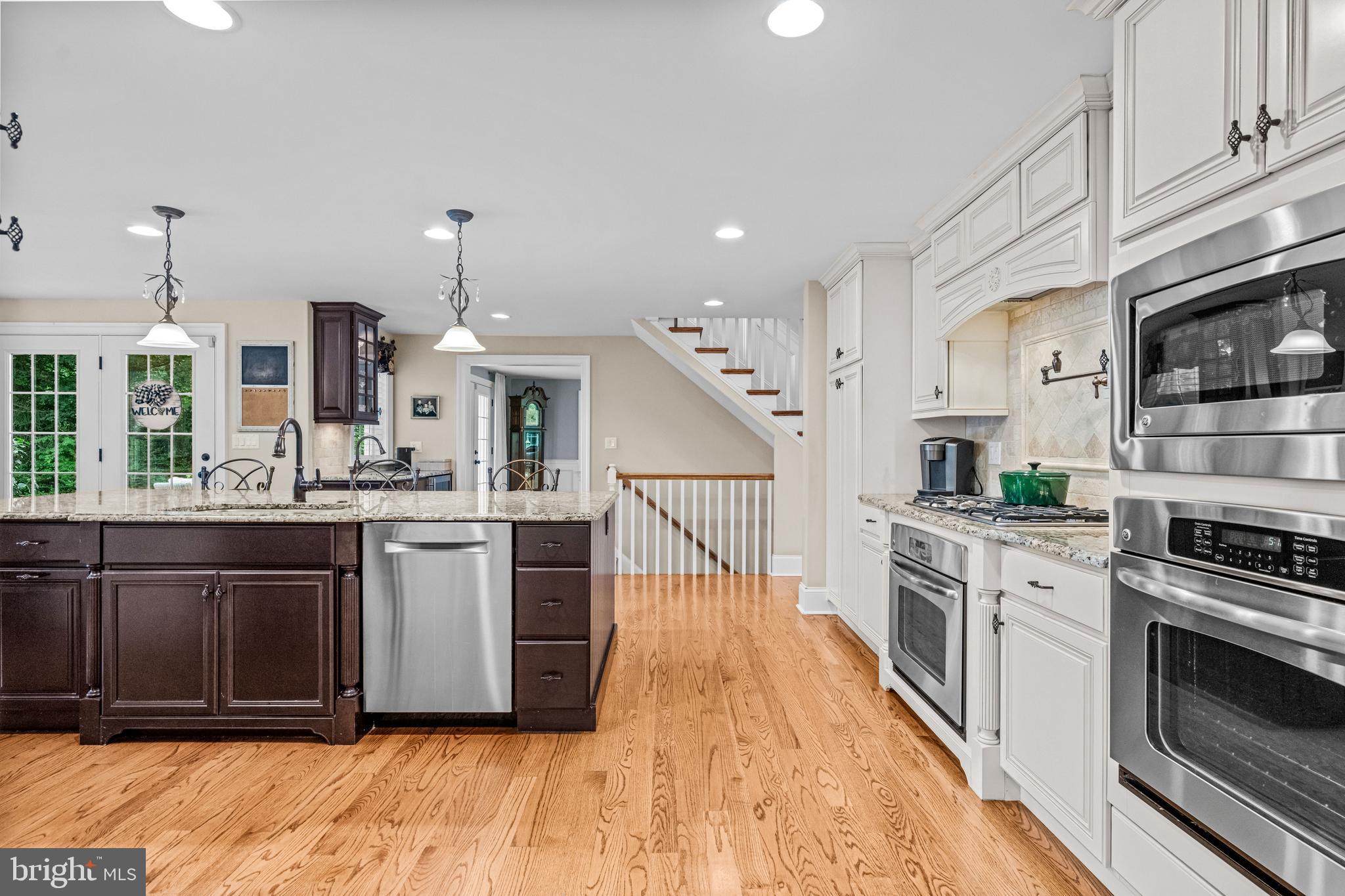 113 Deepdale Road Wayne, PA 19087 - Photo 15 of 68 a kitchen with kitchen island granite countertop wooden floors and stainless steel appliances