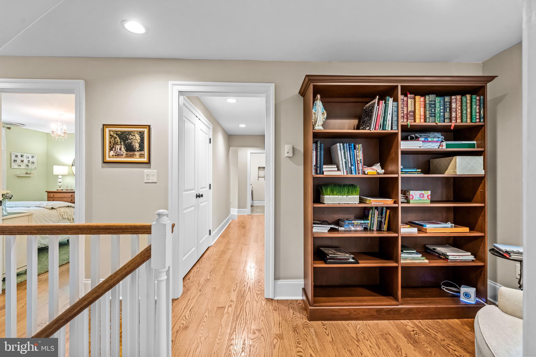 113 Deepdale Road Wayne, PA 19087 - Photo 31 of 68 a view of a hallway with bookshelf and wooden floor