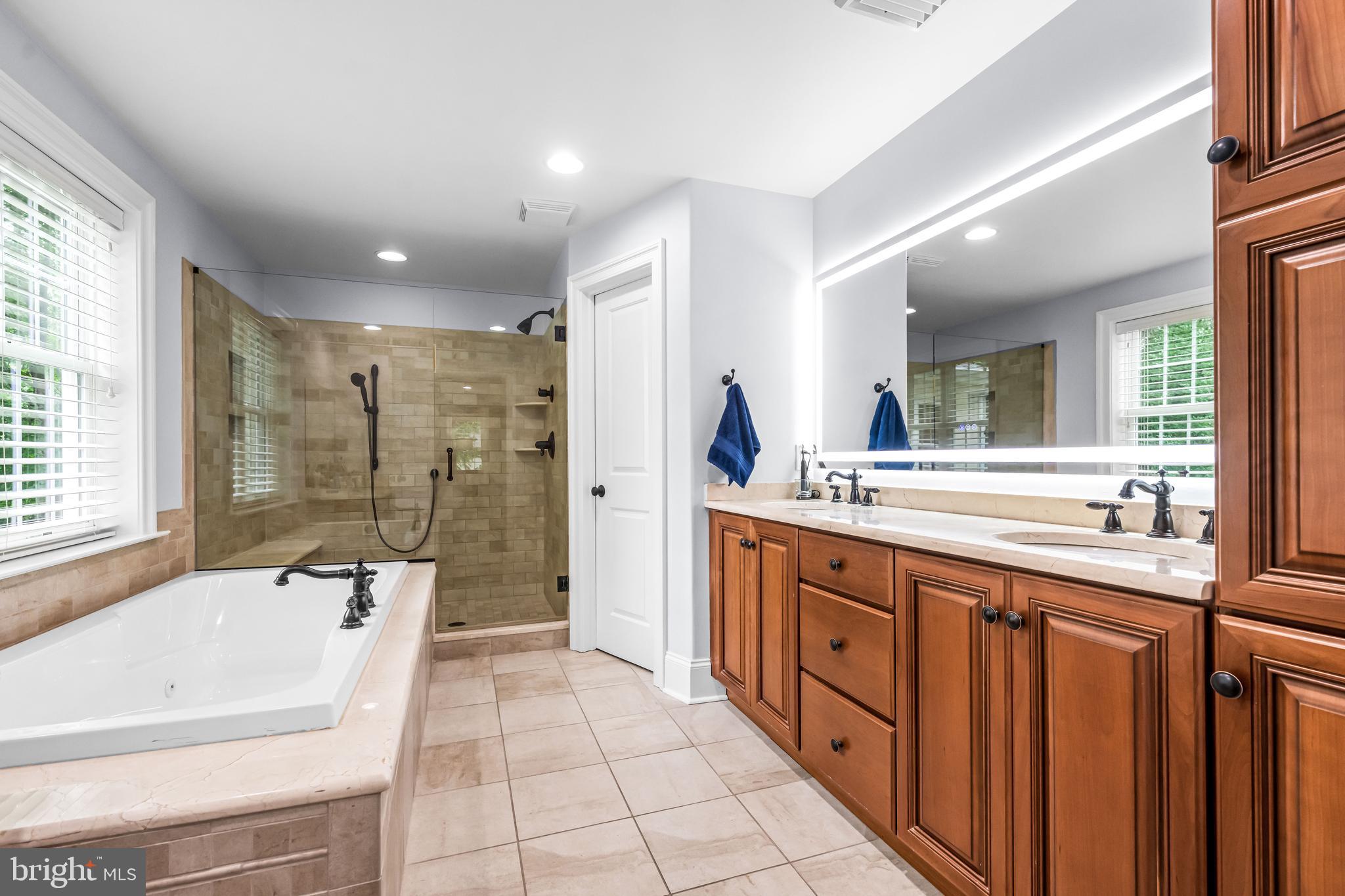113 Deepdale Road Wayne, PA 19087 - Photo 36 of 68 a spacious bathroom with a double vanity sink a large mirror and a bathtub