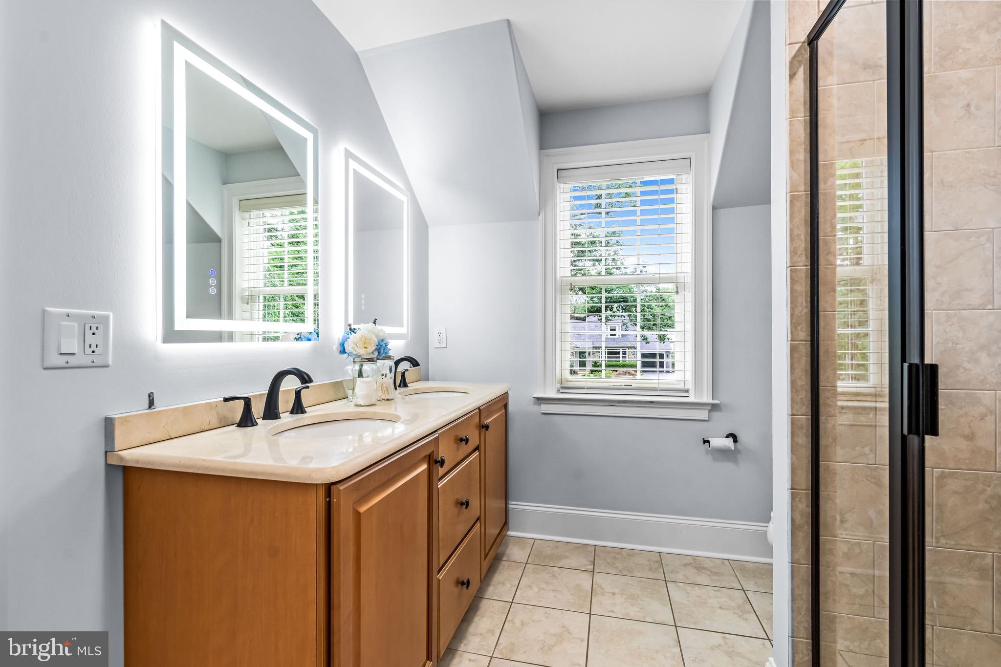 113 Deepdale Road Wayne, PA 19087 - Photo 45 of 68 a bathroom with a sink a mirror and a bathtub next to a window