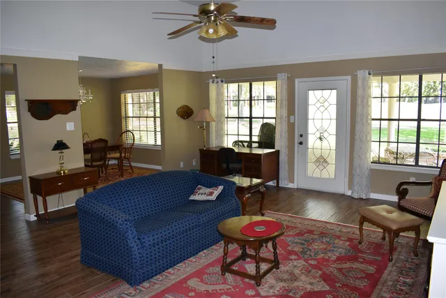 a living room with furniture a table and wooden floor