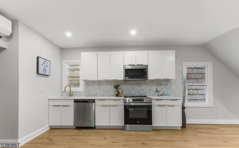 321 William Street, Unit 1 Harrison, NJ 07029 - Photo 4 of 15 a kitchen with stainless steel appliances a sink stove and microwave