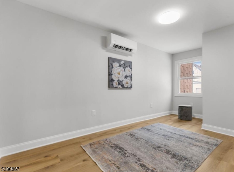 321 William Street, Unit 1 Harrison, NJ 07029 - Photo 9 of 15 an empty room with wooden floor and window