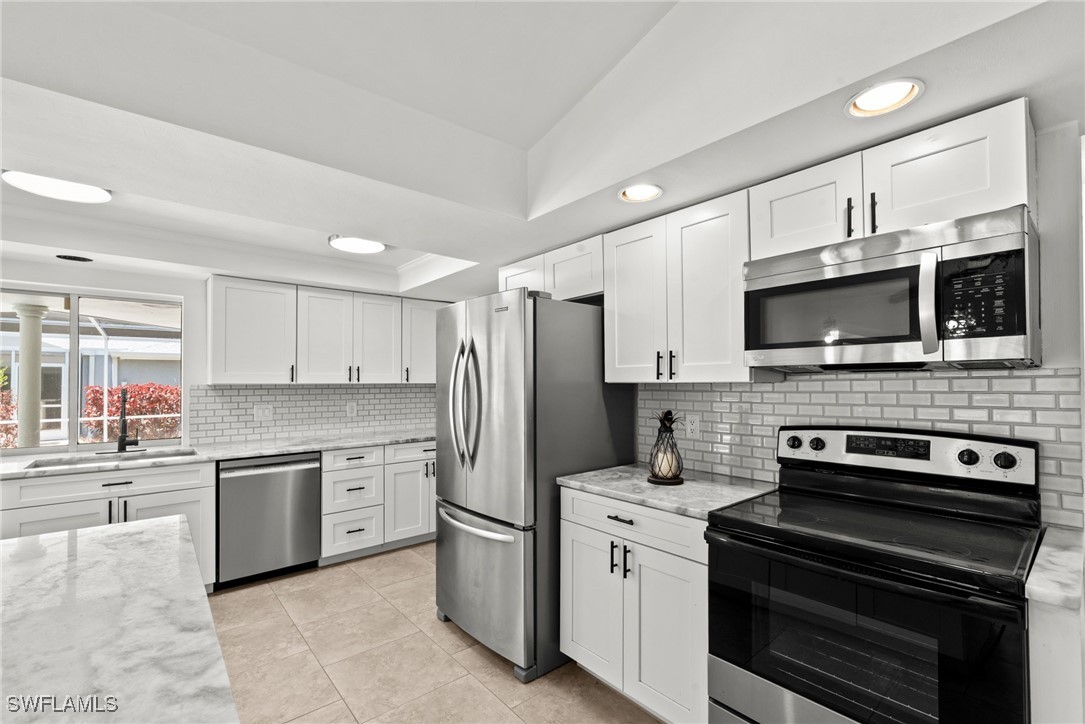 12331 McGregor Boulevard Fort Myers, FL 33919 - Photo 12 of 46 a kitchen with stainless steel appliances a stove microwave and sink