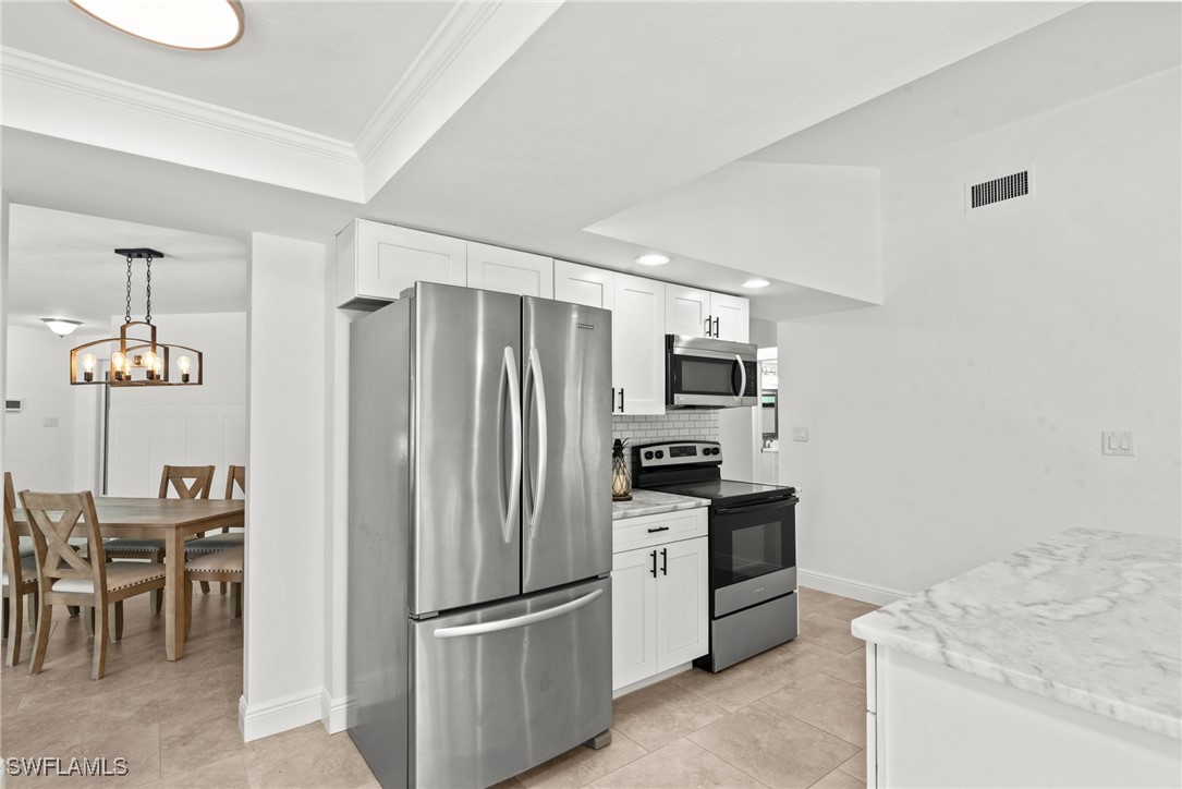12331 McGregor Boulevard Fort Myers, FL 33919 - Photo 14 of 46 a kitchen with stainless steel appliances a refrigerator and a stove top oven