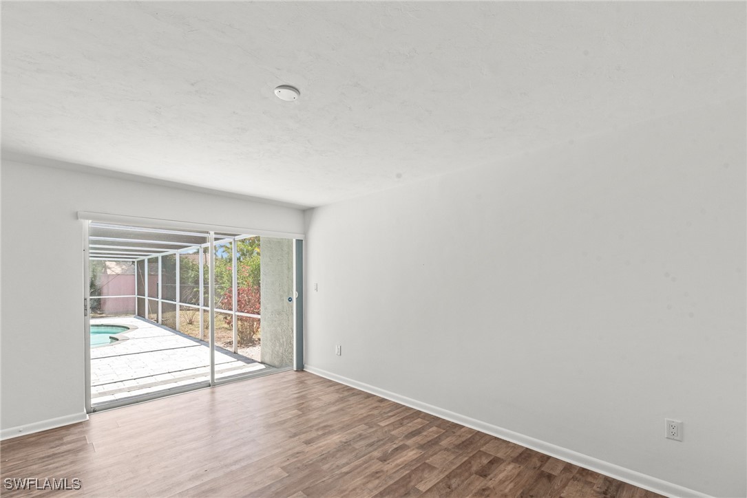 12331 McGregor Boulevard Fort Myers, FL 33919 - Photo 21 of 46 an empty room with wooden floor and windows
