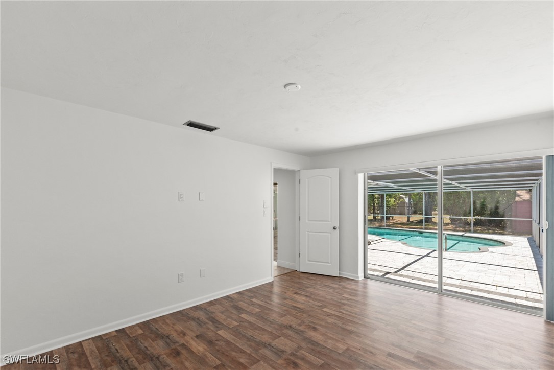 12331 McGregor Boulevard Fort Myers, FL 33919 - Photo 22 of 46 an empty room with wooden floor and windows