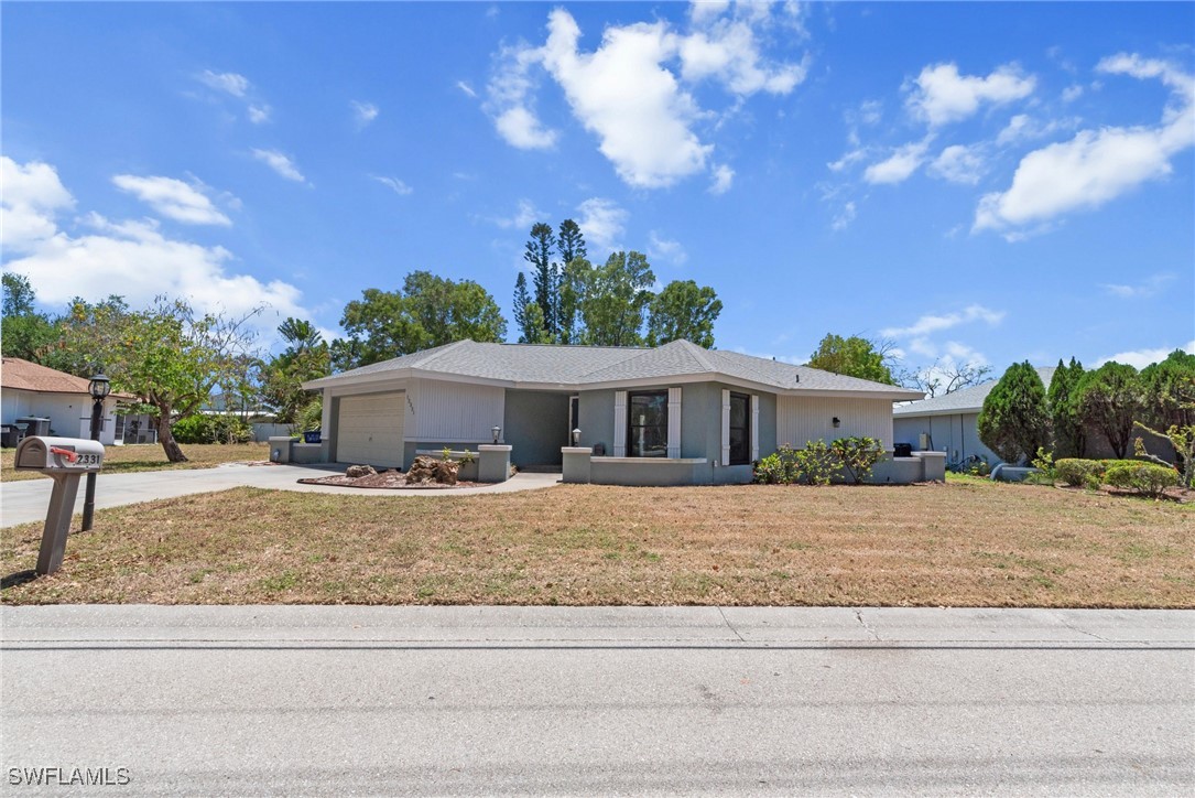 12331 McGregor Boulevard Fort Myers, FL 33919 - Photo 44 of 46 a front view of a house with a yard and garage