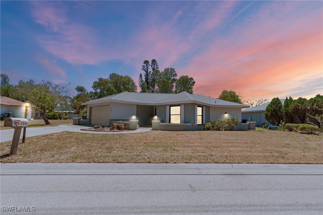 12331 McGregor Boulevard Fort Myers, FL 33919 - Photo 45 of 46 a front view of a house with a yard and garage