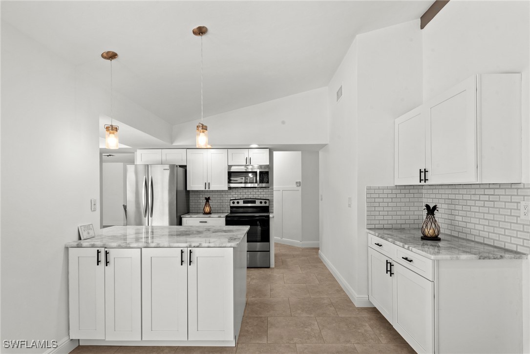 12331 McGregor Boulevard Fort Myers, FL 33919 - Photo 8 of 46 a large white kitchen with stainless steel appliances kitchen island a sink stove and cabinets