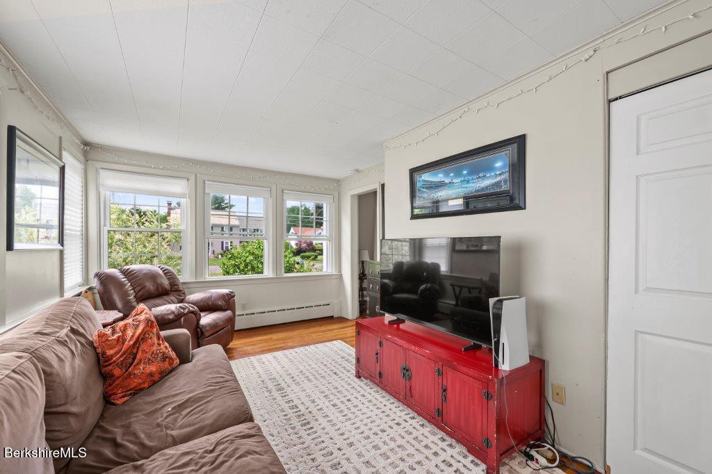 33 Eleanor Road Pittsfield, MA 01201 - Photo 23 of 45 a living room with furniture a flat screen tv and a floor to ceiling window