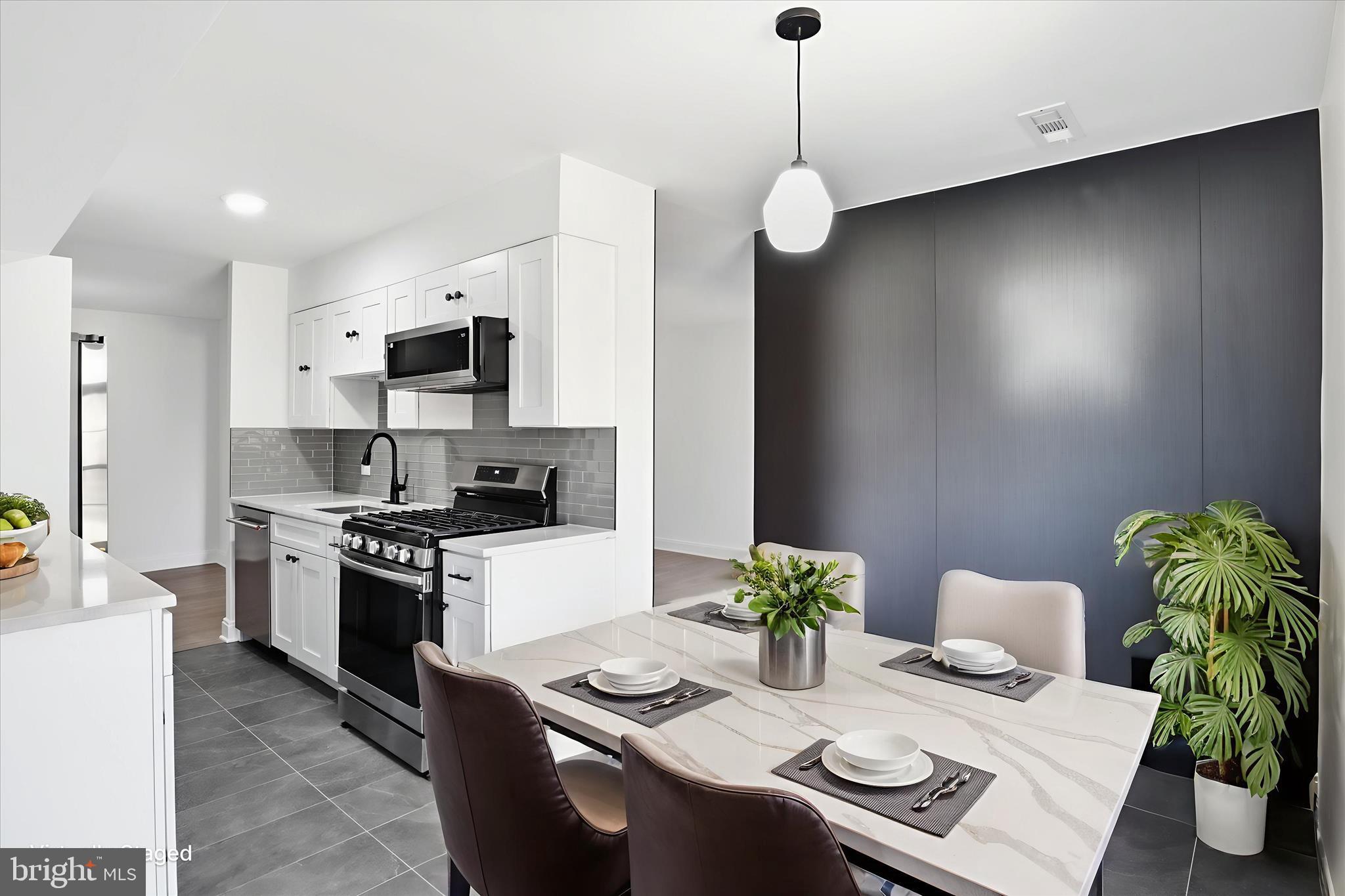 8300 Tobin Road, Unit 23 Annandale, VA 22003 - Photo 4 of 37 a kitchen with stainless steel appliances kitchen island granite countertop a stove a sink a microwave a dining table and chairs