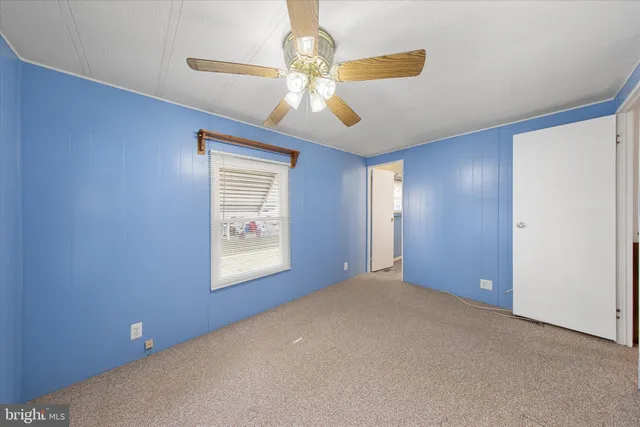 en empty room with closet and a ceiling fan