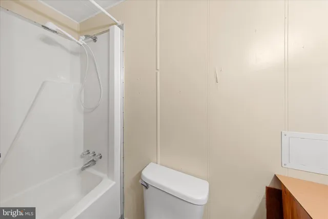 a bathroom with a granite countertop toilet sink and mirror