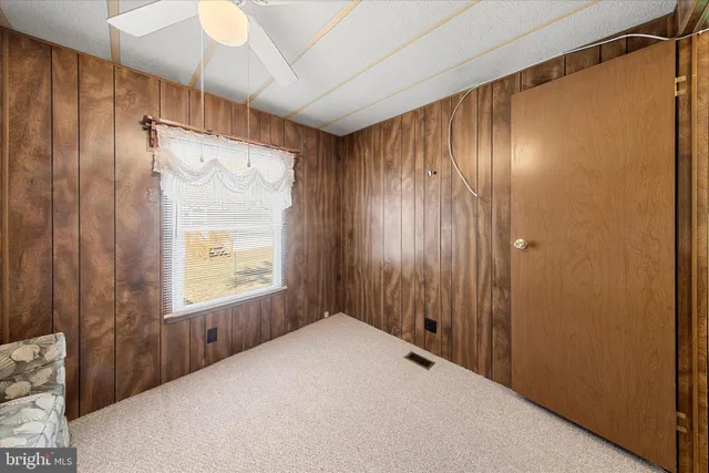 a view of a room that has a fan and a window