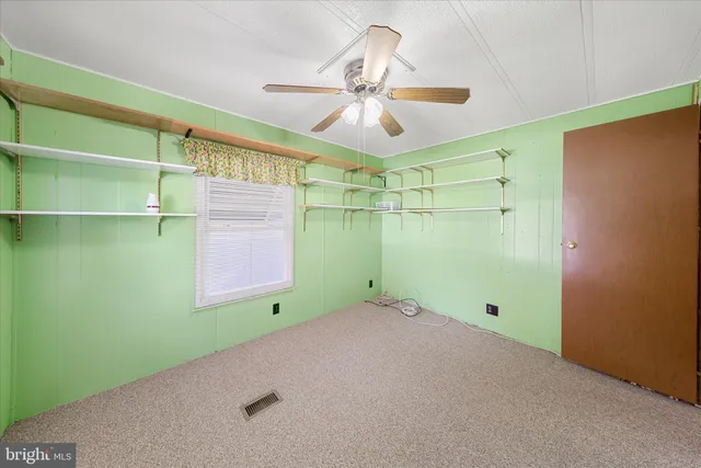 a view of an empty room with a window and a fan