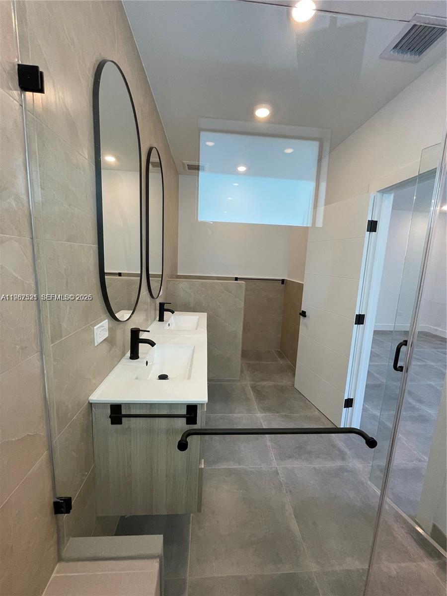 2737 Southwest 2nd Street, Unit 1 Miami, FL 33135 - Photo 11 of 25 a bathroom with a sink a mirror and shower