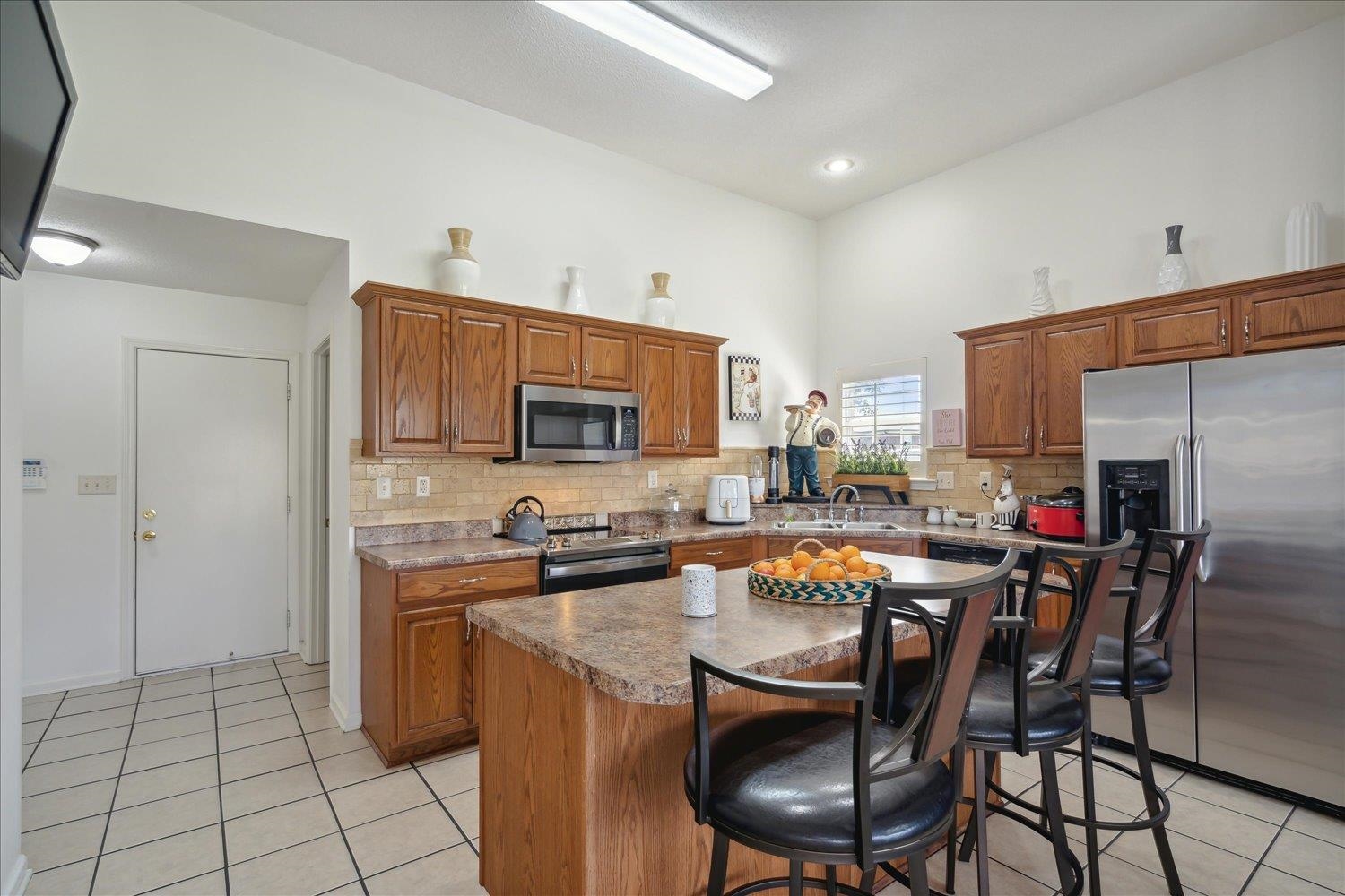 7464 Britt Way Memphis, TN 38125 - Photo 16 of 29 a kitchen with stainless steel appliances a sink a stove a refrigerator cabinets and chairs