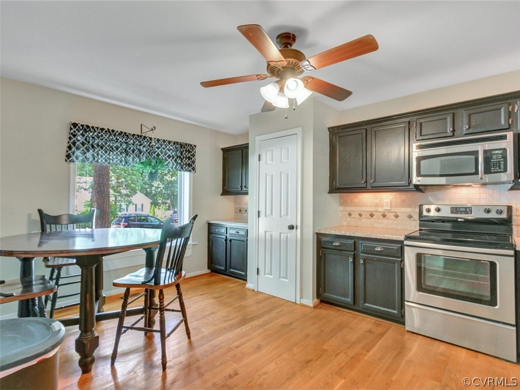 5509 Chatmoss Road Midlothian, VA 23112 - Photo 4 of 38 a kitchen with stainless steel appliances granite countertop a stove a sink dishwasher a dining table and chairs with wooden floor