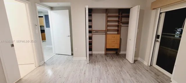 a view of walk in closet with wooden floor