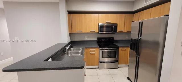 a kitchen with stainless steel appliances granite countertop a refrigerator and a sink