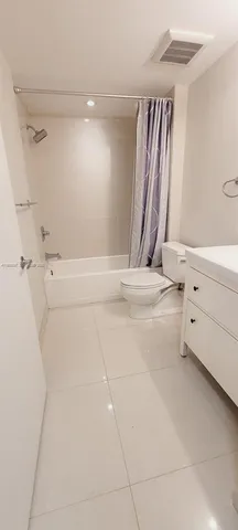 a bathroom with a double vanity sink mirror and bathtub