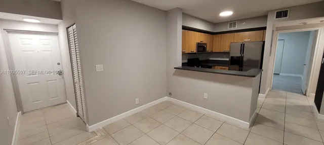 a view of a refrigerator in kitchen and a sink