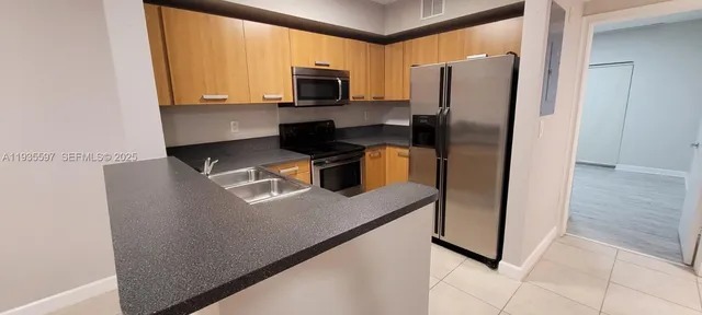 a kitchen with stainless steel appliances a refrigerator sink and microwave