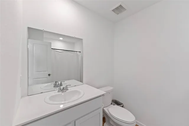 a bathroom with a sink vanity mirror and toilet