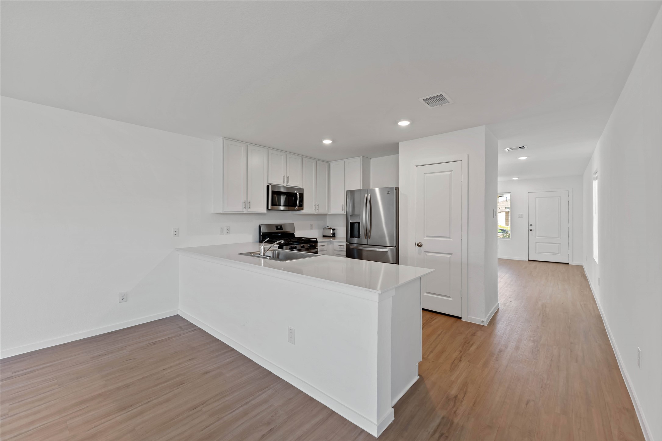 21002 Longwitton Lane Humble, TX 77338 - Photo 4 of 26 a view of a kitchen with a sink and wooden floor