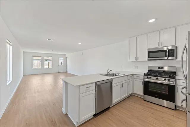 a kitchen with stainless steel appliances granite countertop a stove a sink and a microwave