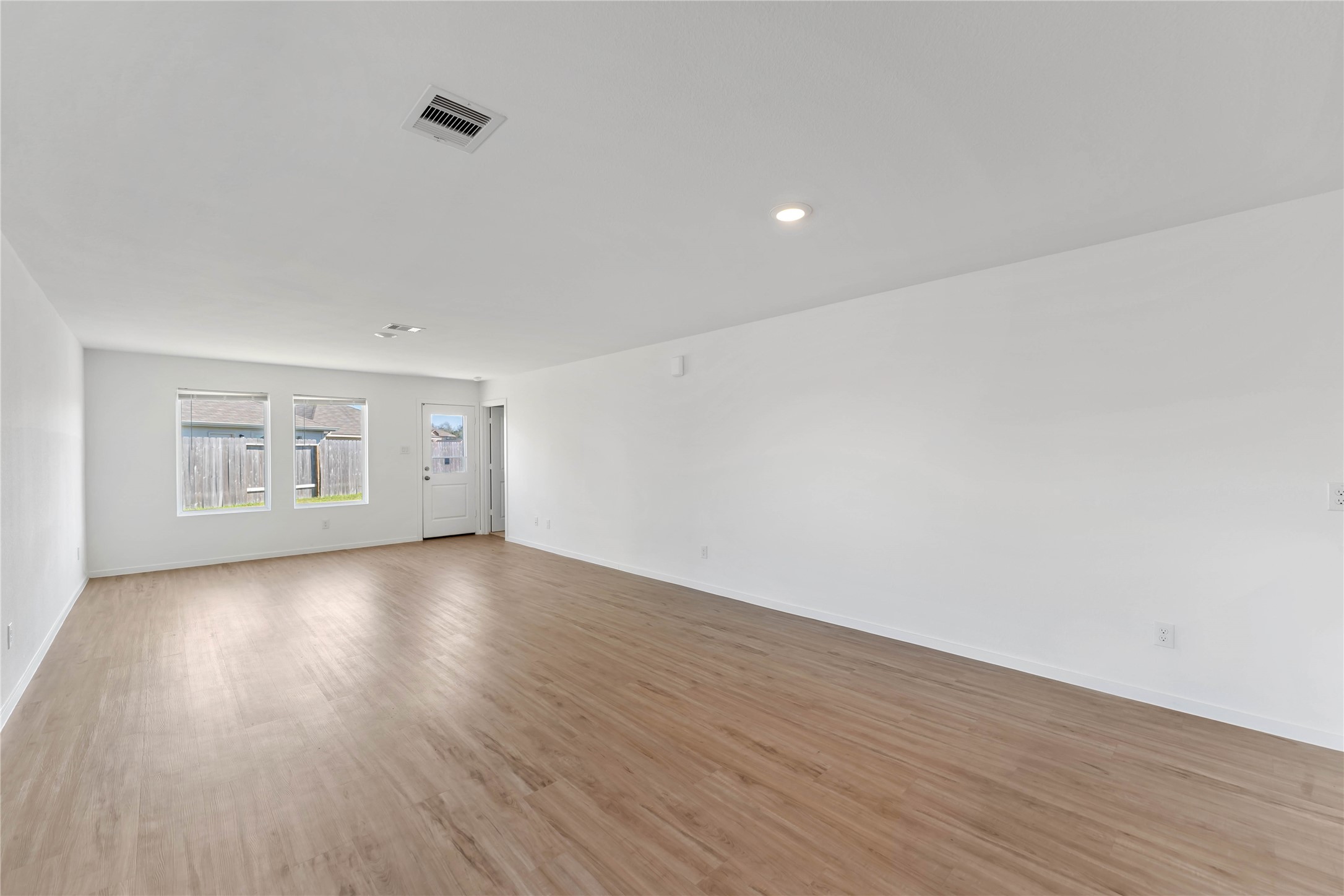 21002 Longwitton Lane Humble, TX 77338 - Photo 8 of 26 a view of an empty room with wooden floor and a window