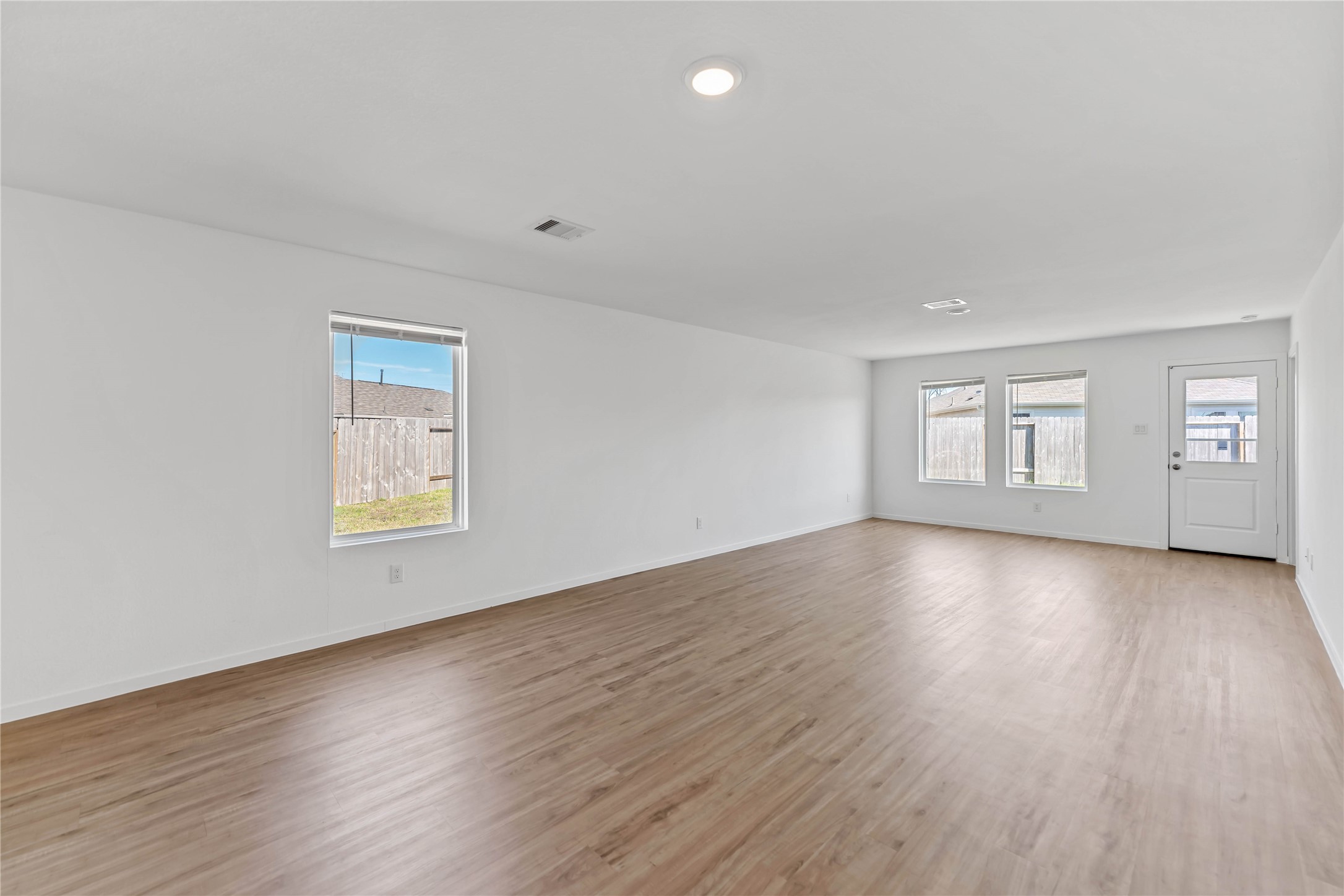 21002 Longwitton Lane Humble, TX 77338 - Photo 9 of 26 a view of an empty room with wooden floor and a window