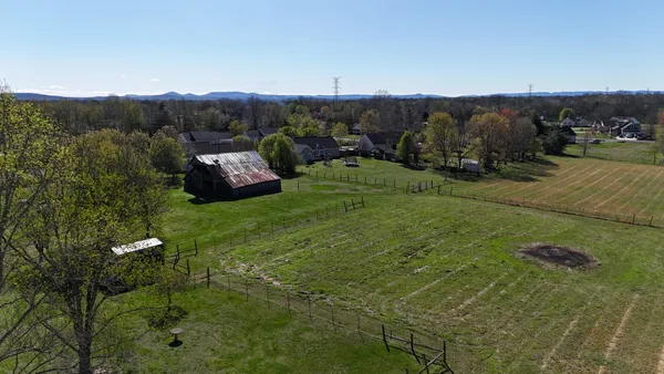 a view of a grassy area with mountains and a houses